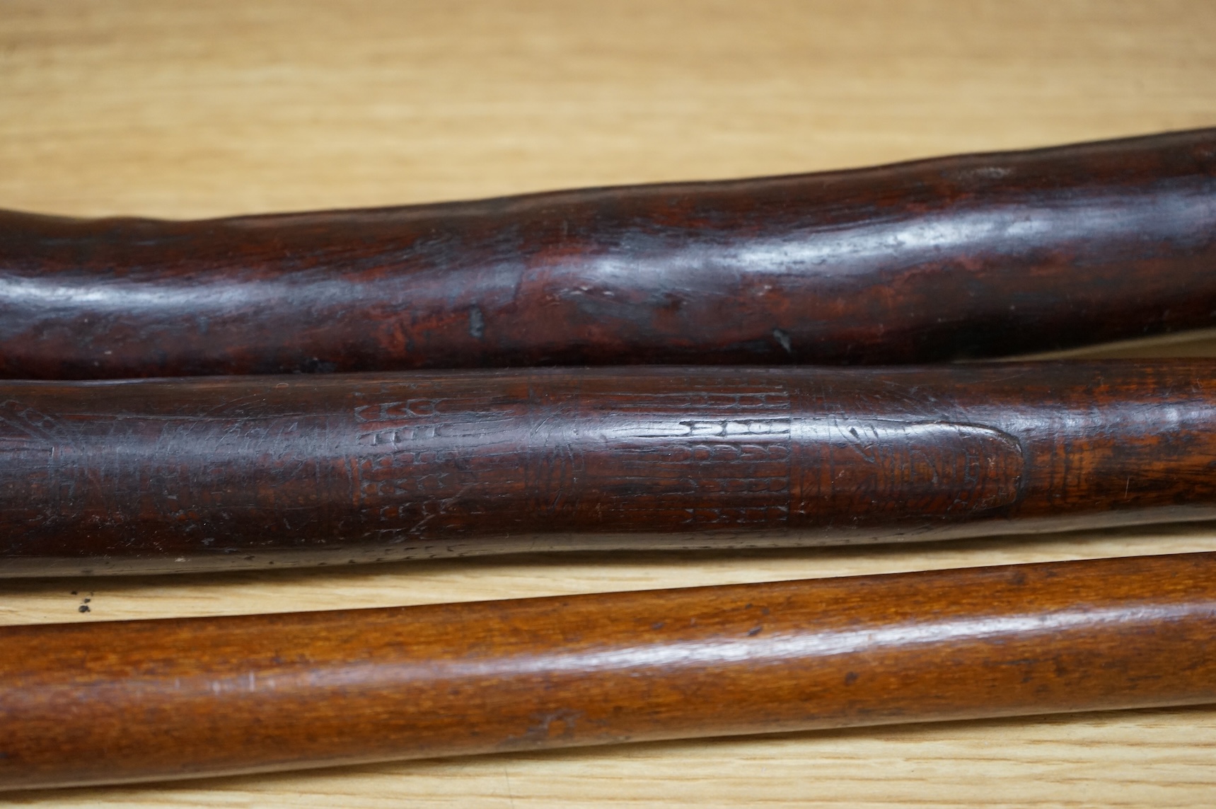 A Fiji hardwood club, probably 19th century or earlier, of gunstock form, overall length 89cm, together with a pole club, probably from Samoa, and a wooden walking stick (3)